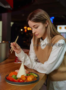 年轻女子专注品尝泰式咖喱虾配椰米饭，温馨餐厅氛围