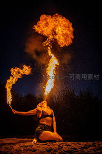 女子跪地喷火表演，夜空下火焰蘑菇云升腾壮观