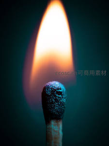 特写燃烧火柴头，蓝灰余烬与明亮锥形火焰形成强烈对比