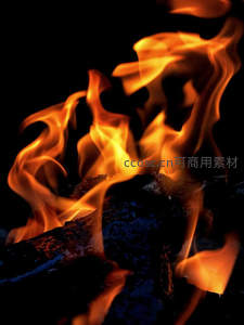 烈焰腾空：木炭余烬上跃动的橙黄火焰特写
