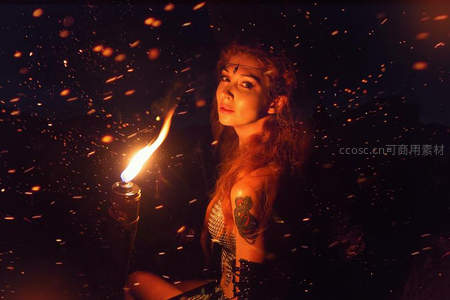 火光中的神秘女子，手持燃烧火炬，火星飞舞如星雨