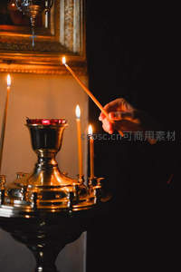教堂内手持长烛点燃圣器，金色烛台映衬宗教庄严氛围，暖光晕染神圣时刻