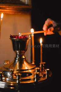 特写宗教烛台点火瞬间，金属光泽与跳动火焰交织，彰显虔诚与传统仪式感