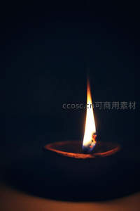 深色背景下孤灯长焰静燃，陶土油灯映出温暖光晕，象征希望与沉思