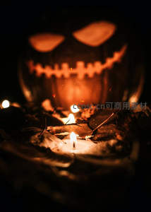 万圣节南瓜灯幽光闪烁，前景小烛摇曳，落叶环绕神秘氛围