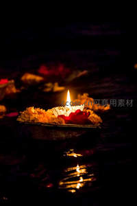 烛火浮于水面，花瓣与纸币环绕，静谧祭奠之景
