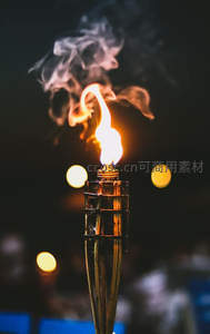 火炬烈焰升腾，烟雾缭绕中透出节日庆典气息