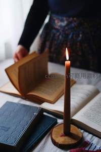 烛光映书页，复古裙装女子轻翻旧书，静谧阅读时光