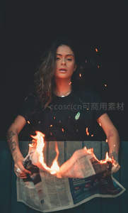 女子手持燃烧报纸，火花飞溅的戏剧性人像摄影