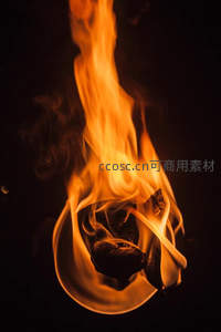 暗夜中纸张卷曲燃烧，橙黄火焰升腾如舞动精灵