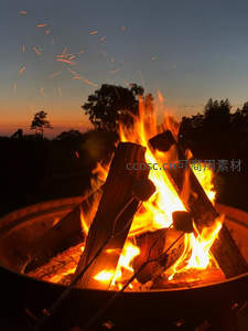 暮色庭院火盆中烤棉花糖，火星飞溅如星雨划破天际