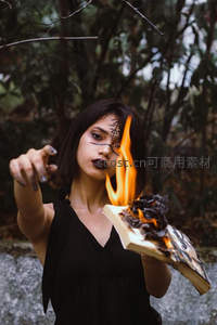 黑衣女子手持焚书，火焰升腾映照神秘符文与冷峻眼神