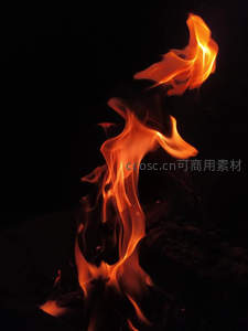 夜色中跃动的火焰特写，橙红光影在黑暗中舞动燃烧
