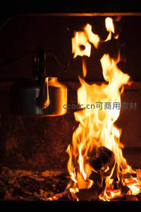 壁炉火焰跃动，老式金属水壶悬于火上，暖光映照砖墙纹理