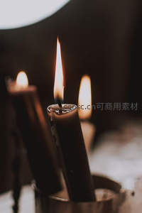 三支黑蜡烛在金属杯中静静燃烧，暖光摇曳如冥想时刻