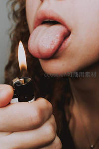 女子伸舌靠近打火机火焰，特写呈现危险又诱惑瞬间