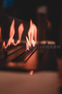 现代燃气壁炉火焰特写，金属格栅间跃动暖橙色火舌