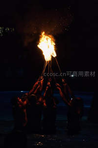 多人合力高举火把，夜空下火焰聚合成璀璨光冠，仪式感十足