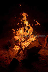 夜幕篝火熊熊燃烧，火焰跃动映照砂石地面与暗影轮廓