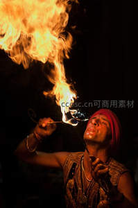 印度火舞表演者仰首喷火，金焰腾空而起，神情专注虔诚
