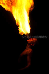 男子仰头喷火表演，烈焰腾空照亮夜幕，震撼视觉冲击力强
