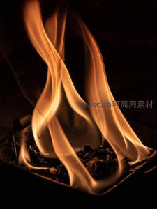 微距镜头下燃烧的炭火，橙黄火焰如丝带般优雅舞动