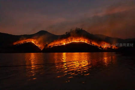 山火夜景航拍：火线蜿蜒山脊映照湖面，橙光倒影如熔金流动，自然力量震撼人心