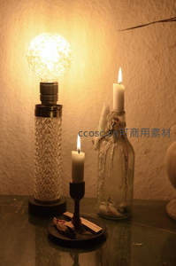 复古灯泡与手工蜡烛并置桌面，暖黄灯光下的怀旧静物组合