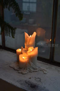 融蜡烛群簇拥窗边，光影交织的冬日静物微距画面