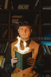 蒸汽朋克风格男子捧燃书直视镜头
