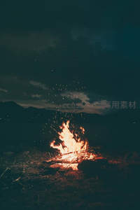 夜空下篝火迸溅星火，暗云低垂，天地间一簇温暖光明