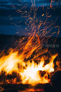近景篝火烈焰腾空，飞溅火星交织成炽热光网