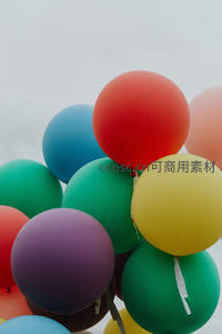 多彩哑光气球群悬浮于灰白天空，清新活泼节日氛围