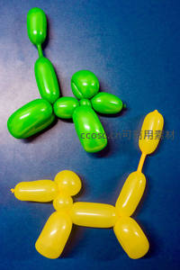 蓝底上绿色与黄色气球动物造型特写，创意派对装饰微距摄影