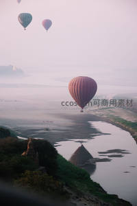 晨雾中热气球掠过缅甸伊洛瓦底江与佛塔群航拍