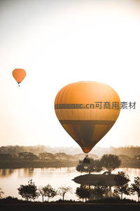 晨光中双热气球掠过湖畔树影倒影