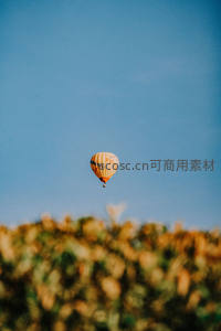 单只格纹热气球悬停湛蓝晴空之上