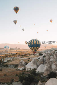 热气球漫天飘浮于格雷梅山谷，岩石锥林映衬蔚蓝天空
