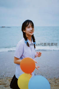 少女海边持彩球微笑回眸，海风轻拂双辫，青春洋溢如夏日诗篇