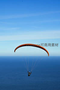 滑翔伞飞越碧海蓝天，橙色伞翼在晴空下划出自由弧线