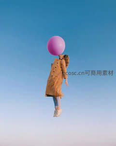 女子身着风衣悬于空中，仰头亲吻巨型粉色气球，蓝天为幕梦幻超现实