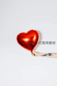 手握金属质感红色心形气球，简约浪漫特写镜头