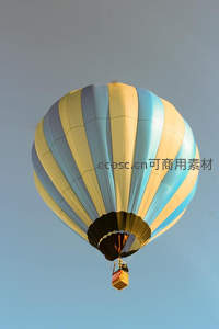 蓝黄条纹热气球升空蓝天，仰拍视角展现庞大气囊结构