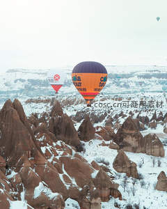 雪覆卡帕多奇亚热气球航拍奇景，橙紫气球掠过岩锥群