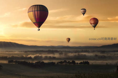 晨曦薄雾中四只热气球缓缓升空，山野静谧如画