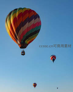 晴空万里多只热气球升空，彩虹条纹主球引人注目