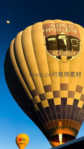 金色热气球印‘世界遗产学院’徽标，逆光燃烧喷焰震撼人心