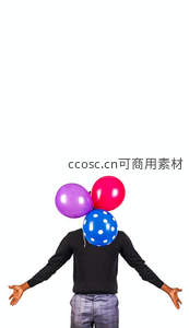 人物用彩色气球遮面张开双臂，白色背景创意摄影