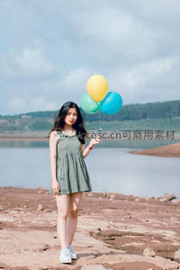 湖畔少女手持彩球，自然光影下的静谧时光