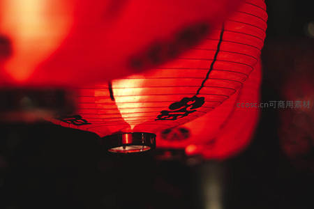 红色纸灯笼特写，透光纹理与黑色书法字迹相映成趣